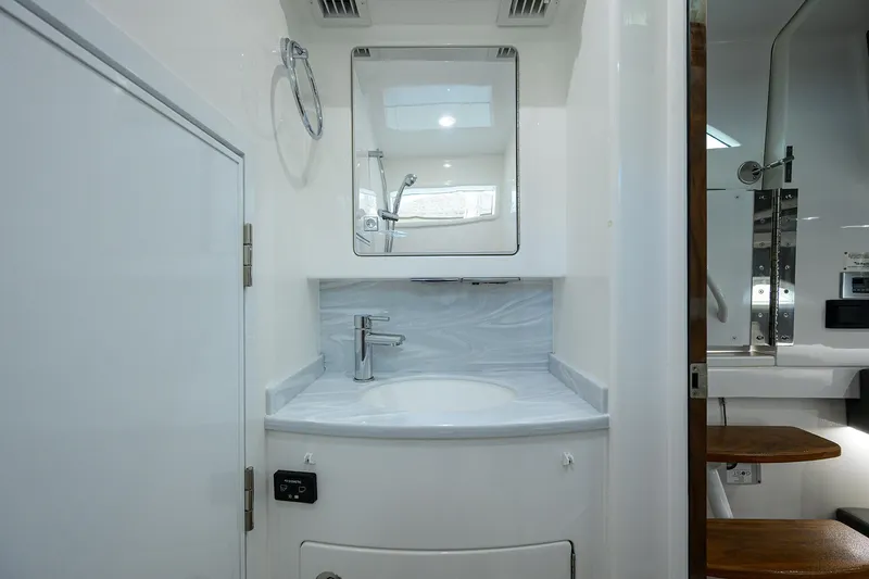 Slide: The Image of 2022 Valhalla V-46 Center Console bathroom with modern sink and mirror. - 21