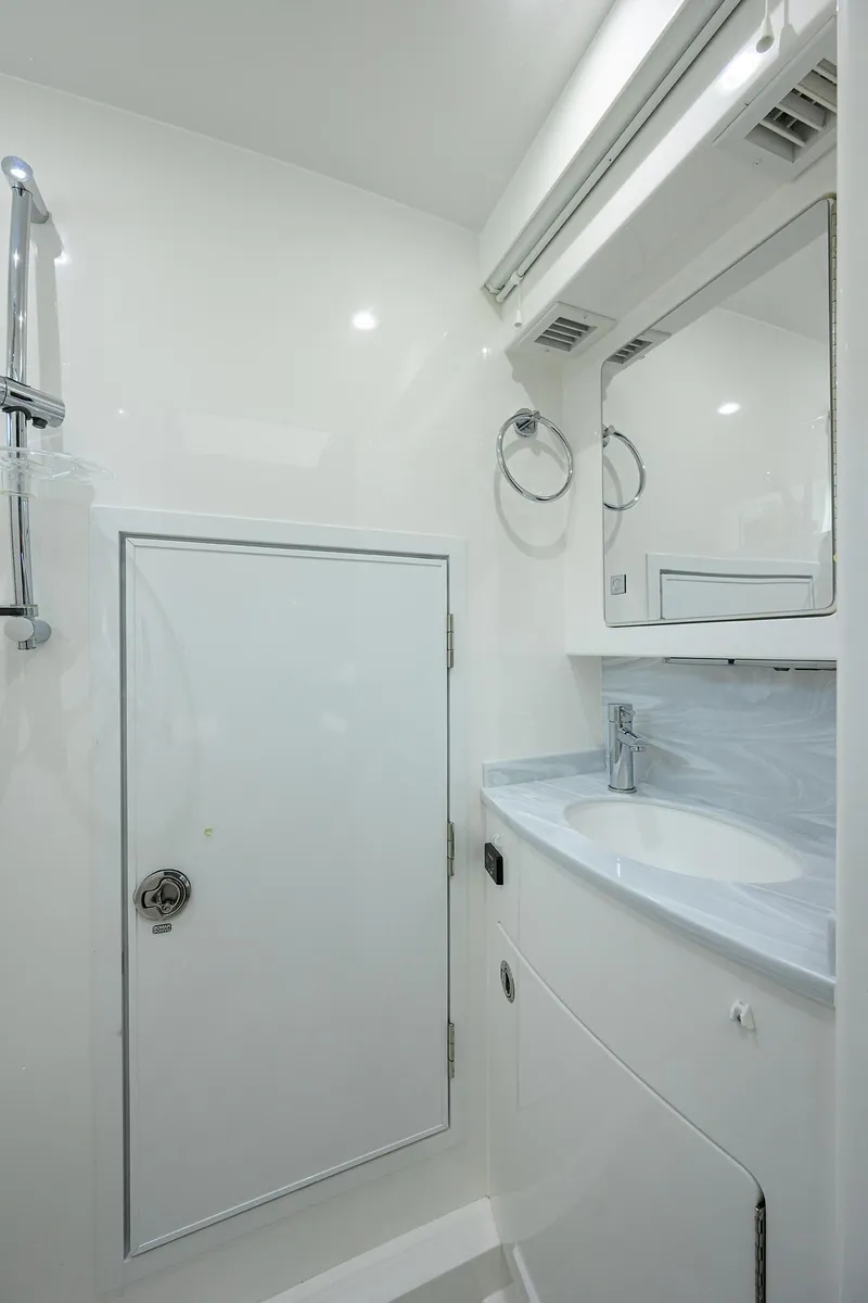 Slide: The Image of 2022 Valhalla V-46 Center Console bathroom with sleek white interior and modern fixtures. - 22