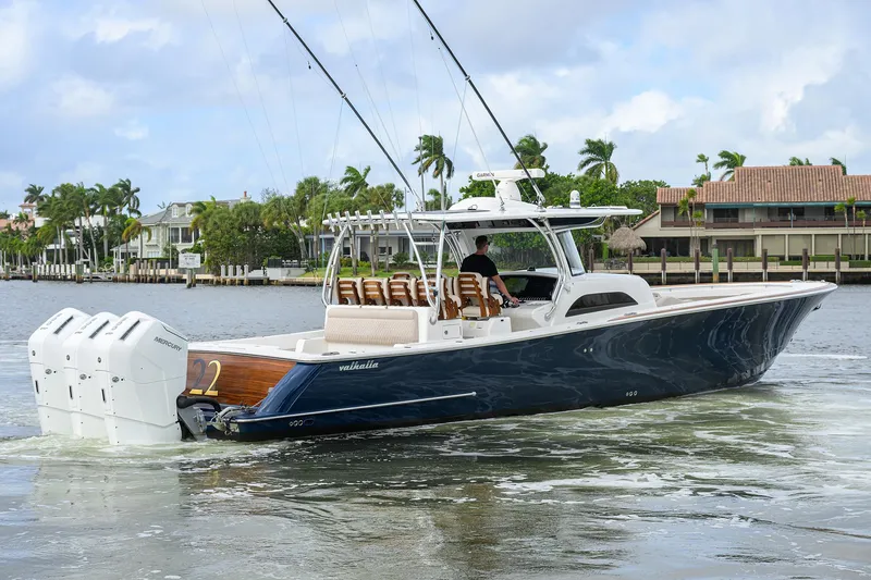 Slide: The Image of 2022 Valhalla V-46 Center Console boat cruising on a scenic waterway. - 27