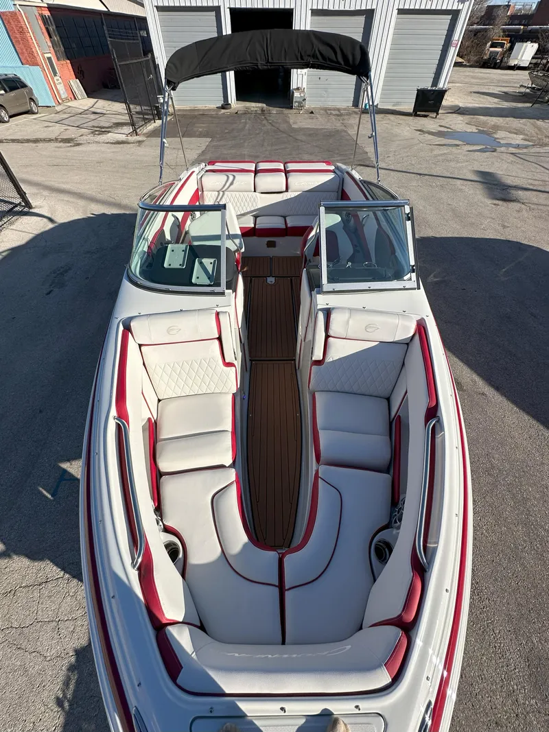 Slide: The Image of 2025 Crownline 240 SS boat with red and white interior, docked outdoors. - 11