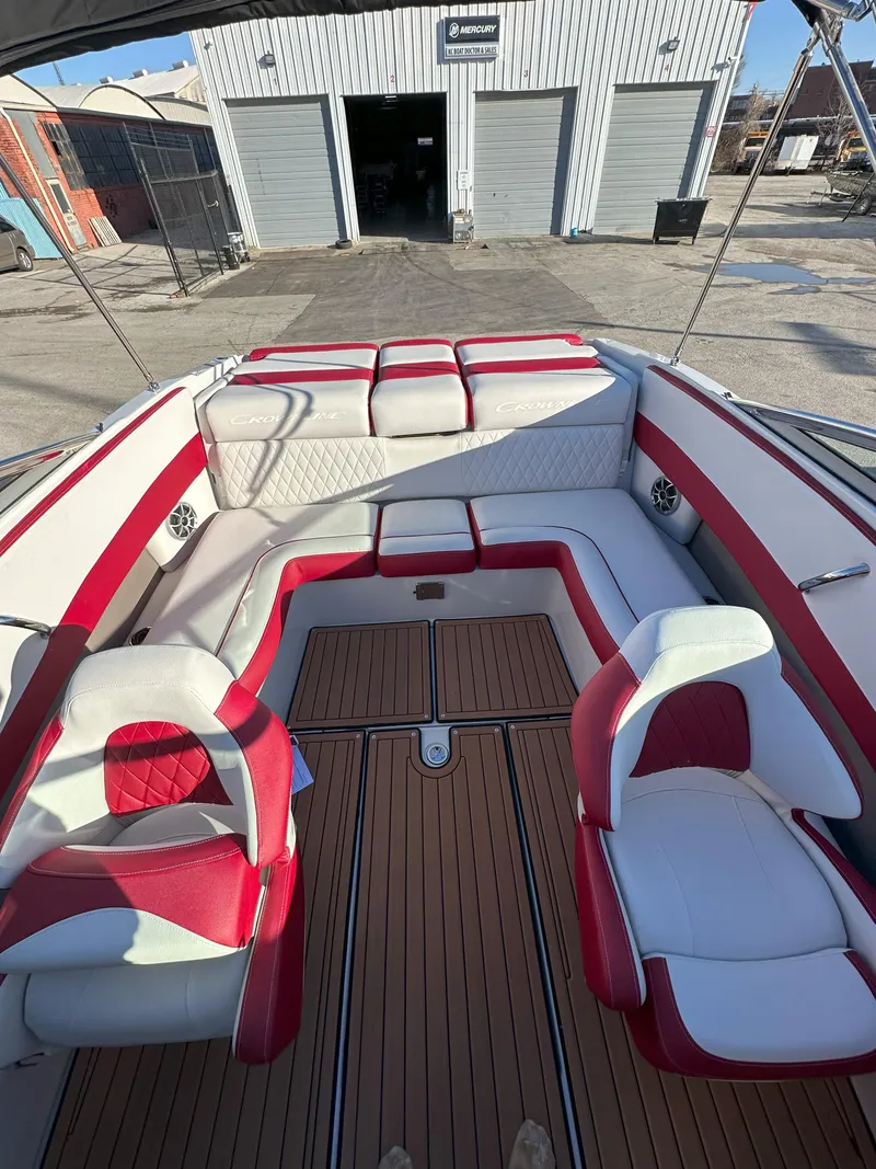 Slide: The Image of 2025 Crownline 240 SS boat interior with red and white seating, wood flooring. - 17