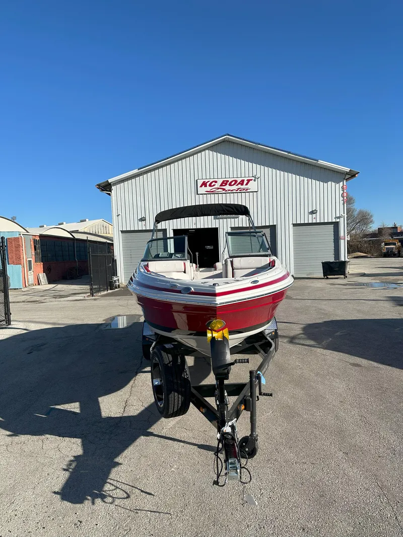 Slide: The Image of 2025 Crownline 240 SS boat on trailer outside KC Boat building. - 2
