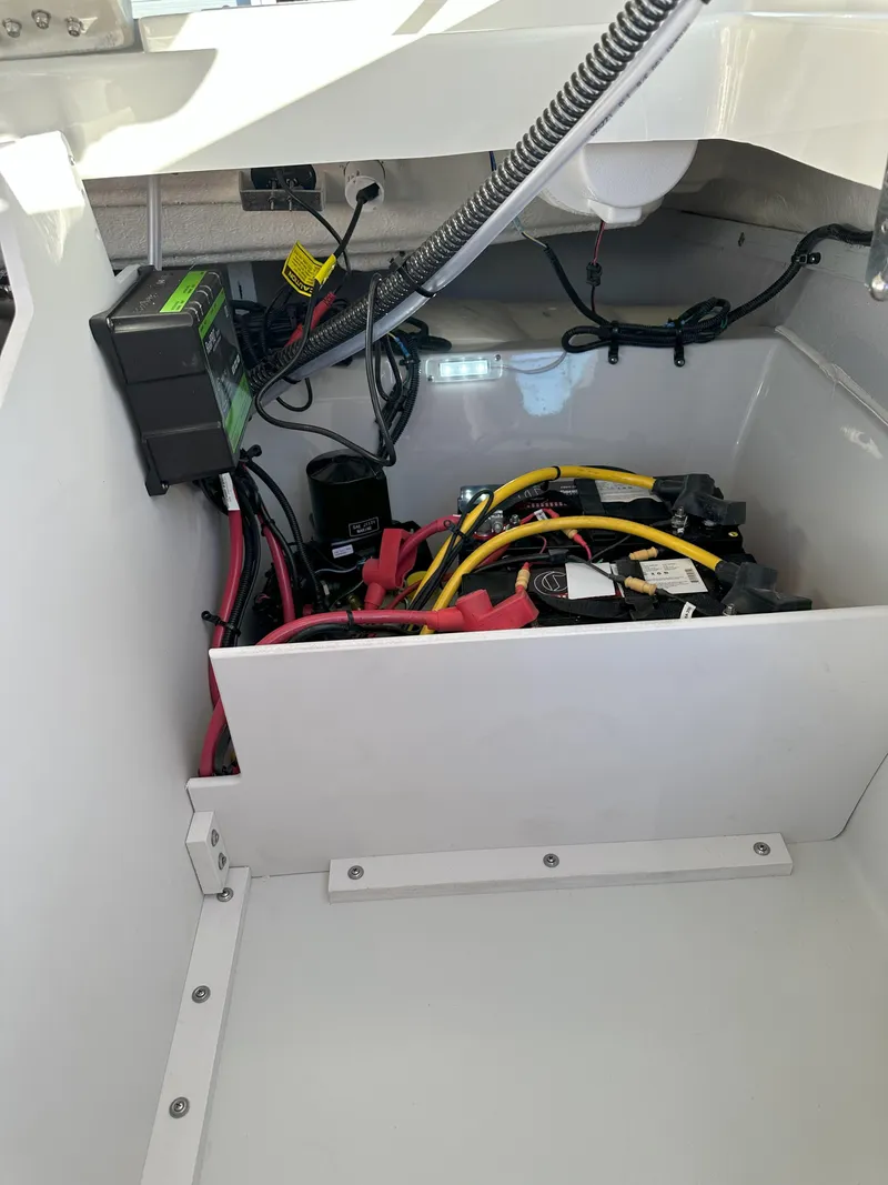 Slide: The Image of 2025 Crownline 240 SS boat battery compartment with wiring and components. - 20