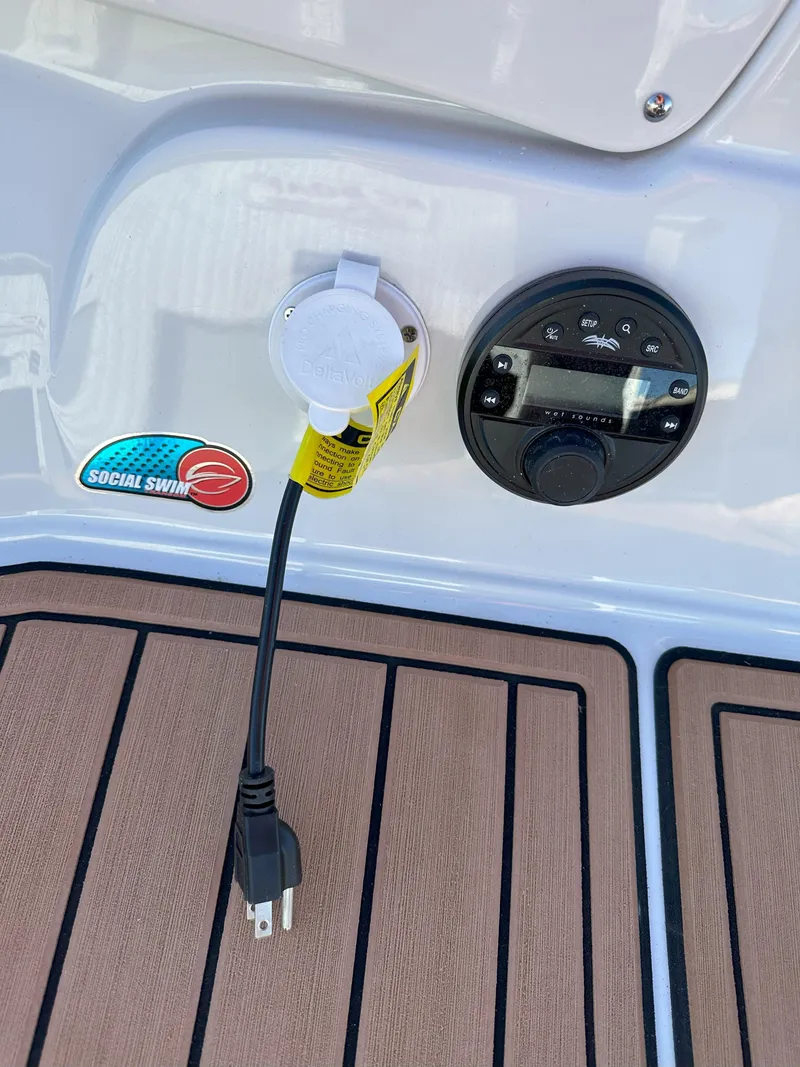 Slide: The Image of 2025 Crownline 240 SS boat electrical outlet and control panel on deck. - 21