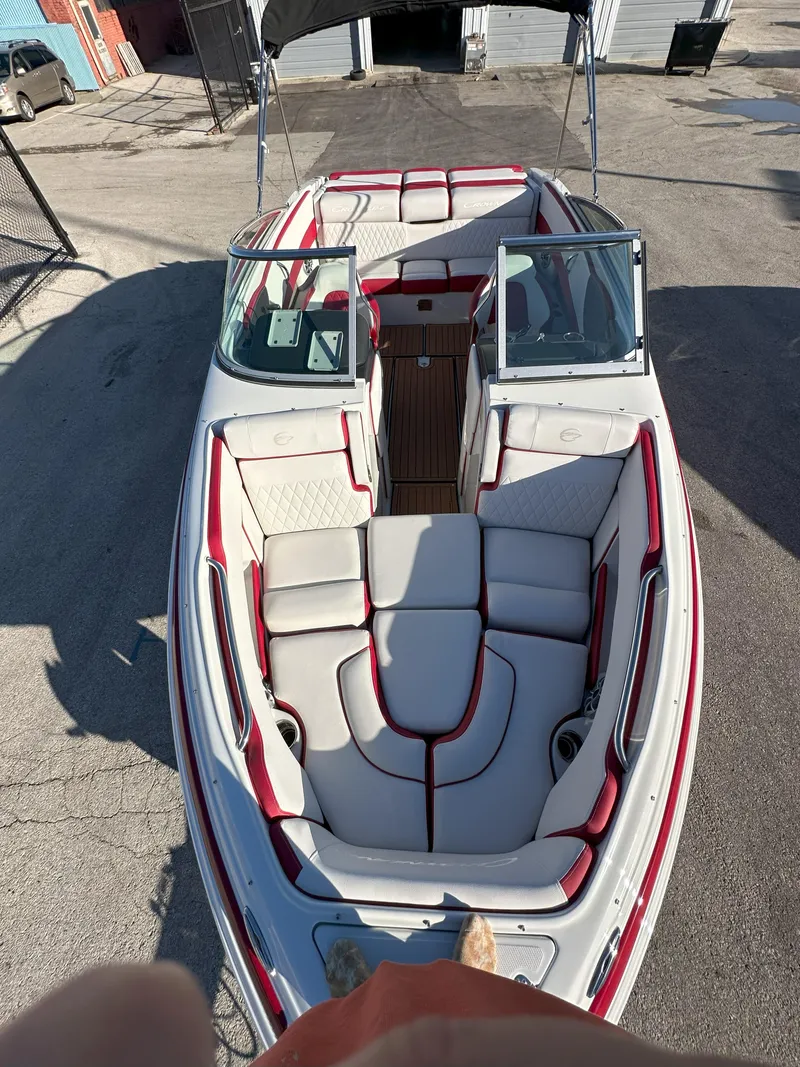 Slide: The Image of 2025 Crownline 240 SS boat with red and white interior, docked outdoors. - 3