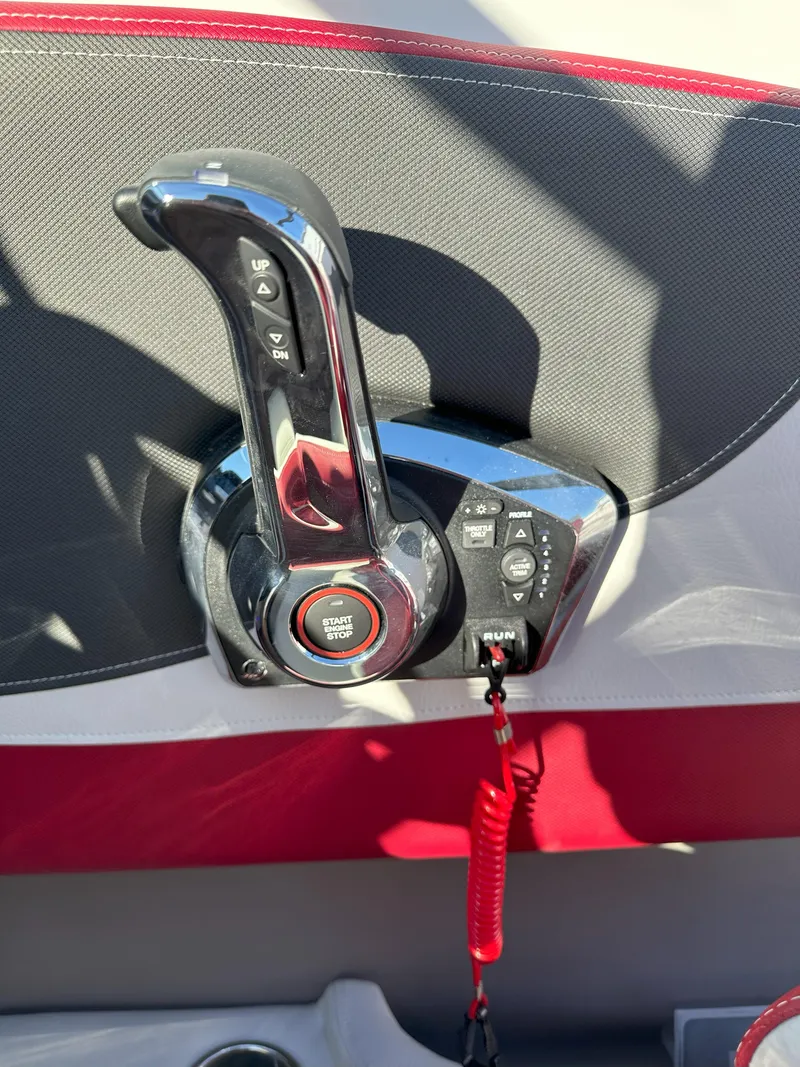 Slide: The Image of Throttle control of 2025 Crownline 240 SS boat with red safety lanyard. - 6