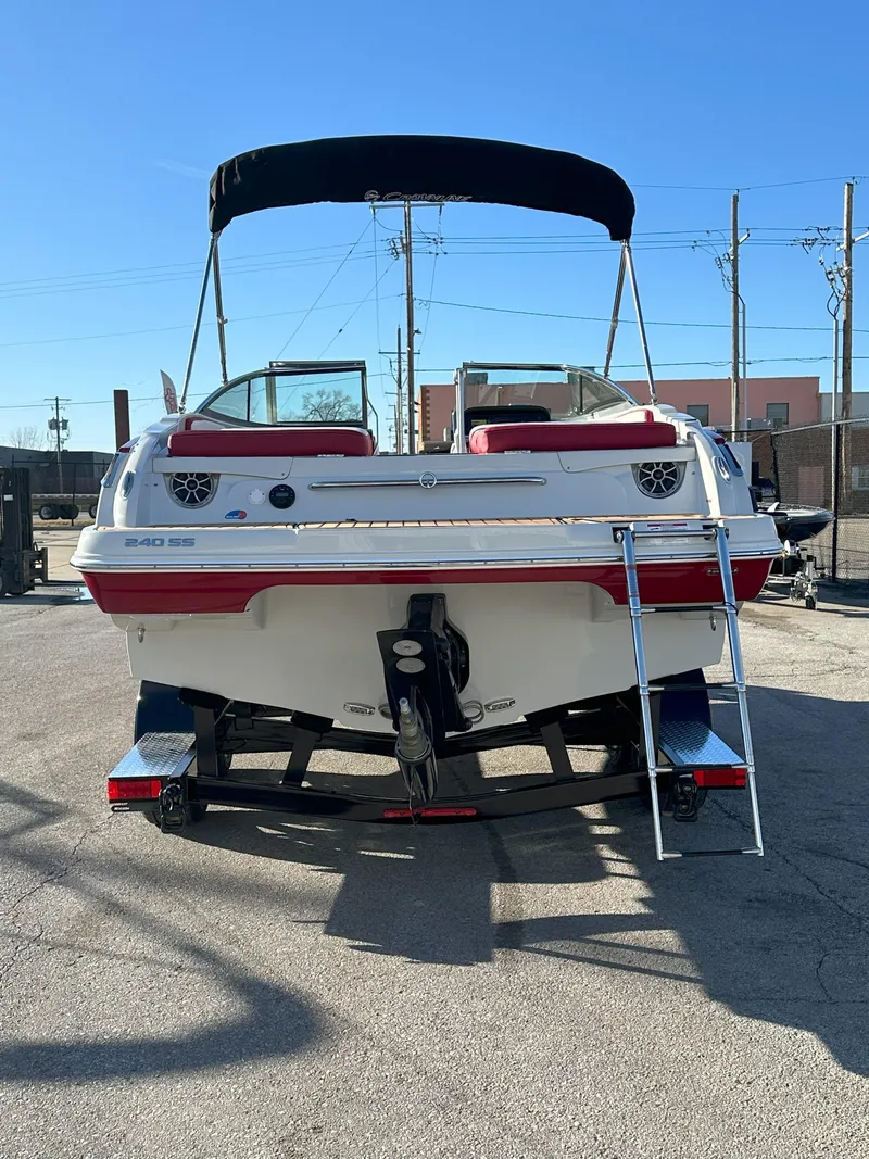 Slide: The Image of 2025 Crownline 240 SS boat with ladder, parked outdoors under clear blue sky. - 8