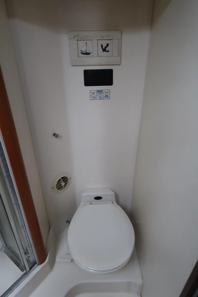 Slide: The Image of 2002 Luhrs 40 Convertible yacht bathroom with compact toilet and control panel. - 32