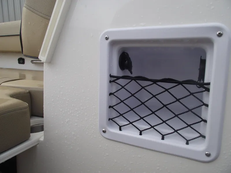 Slide: The Image of 2025 Bayliner D20 boat storage compartment with netting and beige seating. - 17