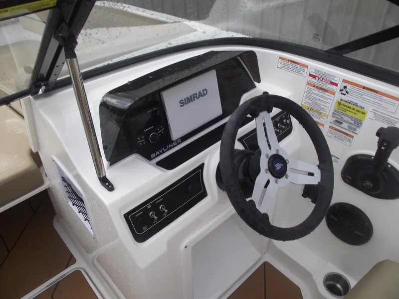 Slide: The Image of 2025 Bayliner D20 boat dashboard with Simrad display and steering wheel. - 20