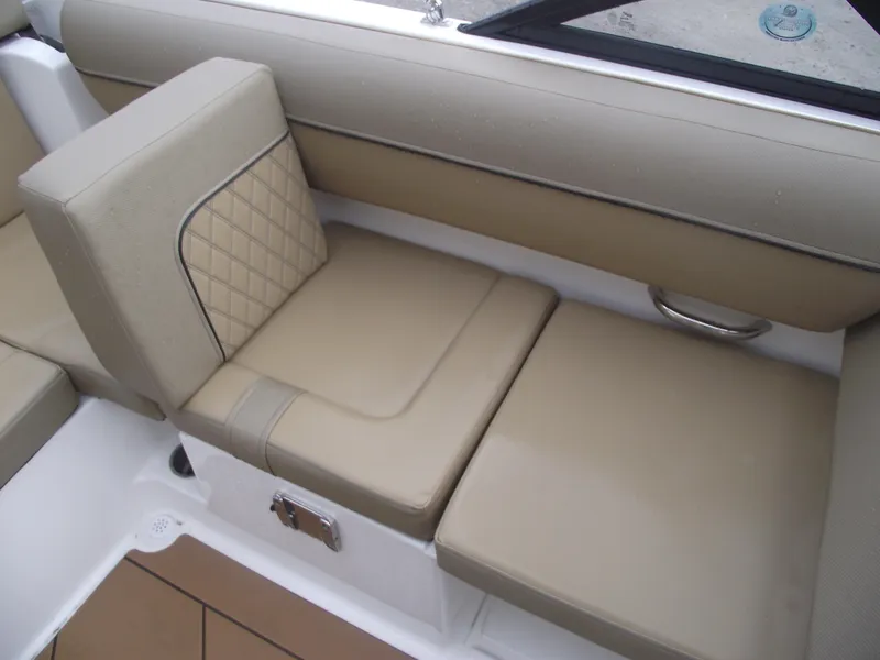Slide: The Image of 2025 Bayliner D20 boat interior with beige cushioned seating and quilted backrest. - 23