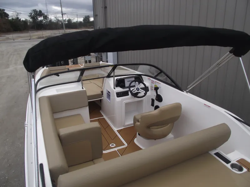 Slide: The Image of 2025 Bayliner D20 boat interior with beige seating and black canopy. - 36