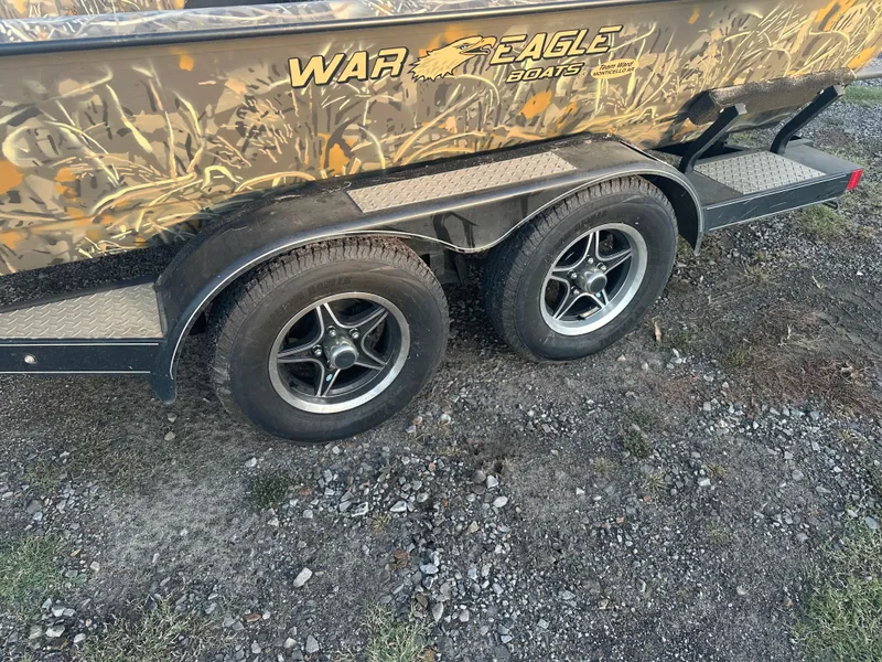 Slide: The Image of 2022 War Eagle 2070 Blackhawk boat trailer with dual wheels on gravel. - 15