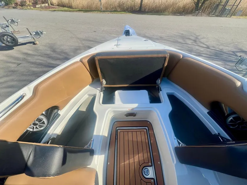 Slide: The Image of 2025 Crownline 310 XSS boat interior with tan seating and wood accents. - 11