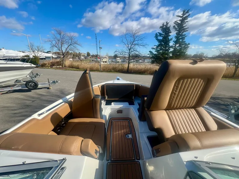 Slide: The Image of 2025 Crownline 310 XSS boat interior with tan leather seats and wood accents. - 12