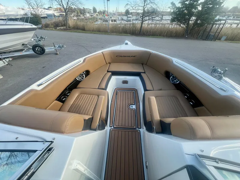 Slide: The Image of 2025 Crownline 310 XSS boat interior with tan seating and wood accents. - 14