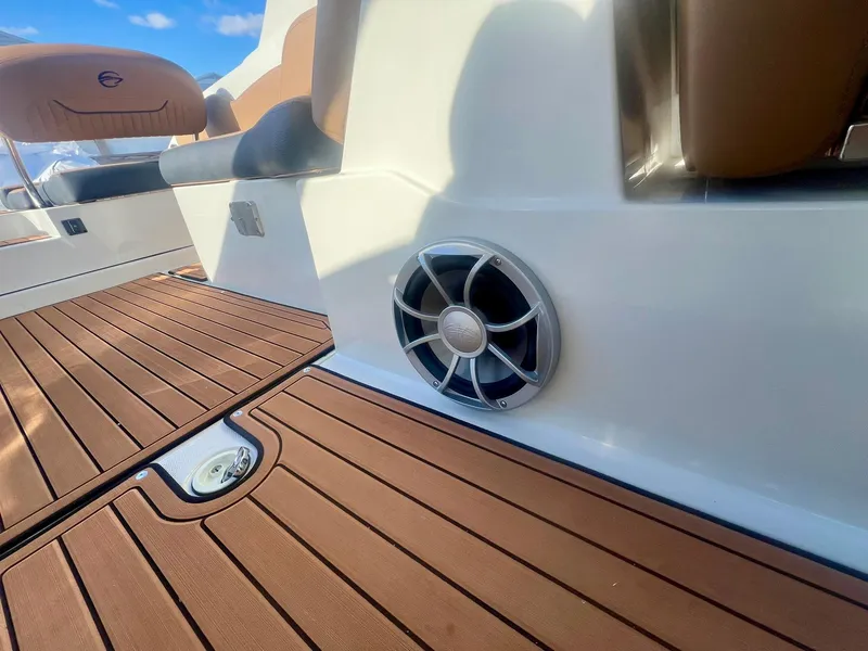 Slide: The Image of Crownline 310 XSS 2025 boat interior with brown decking and speaker. - 16