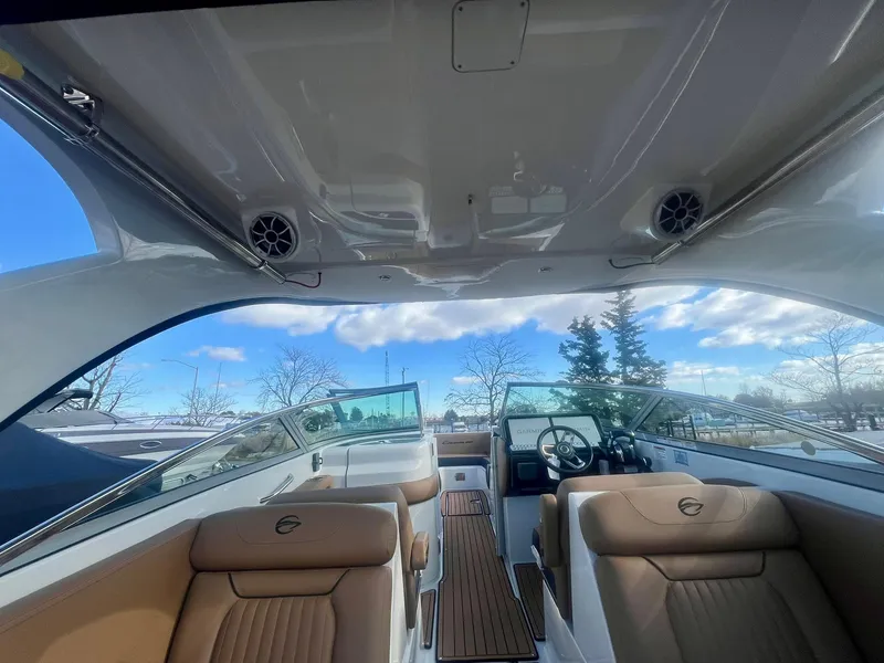 Slide: The Image of 2025 Crownline 310 XSS boat interior with tan seating and open sky view. - 21