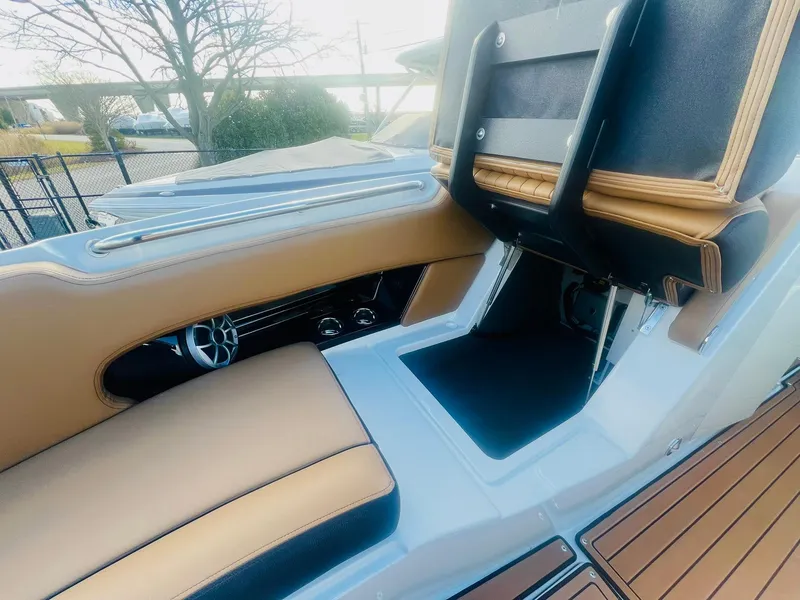Slide: The Image of 2025 Crownline 310 XSS boat interior with tan and black seating, modern design. - 30