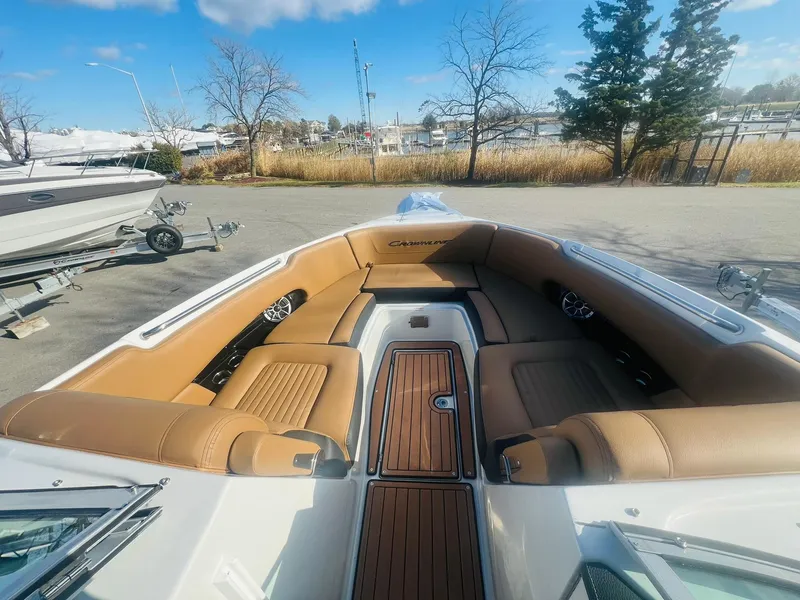 Slide: The Image of 2025 Crownline 310 XSS boat interior with tan seating and wood accents. - 31