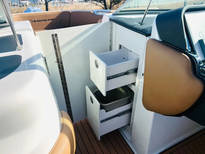 Slide: The Image of 2025 Crownline 310 XSS boat interior with open storage drawers. - 32
