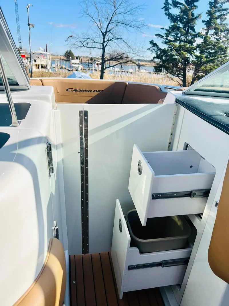 Slide: The Image of 2025 Crownline 310 XSS boat interior with open storage drawers. - 33