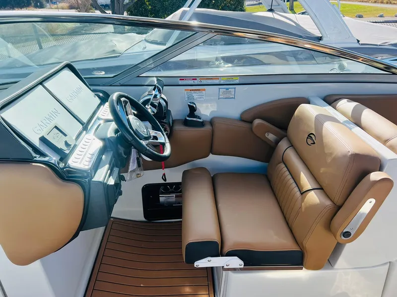 Slide: The Image of 2025 Crownline 310 XSS boat interior with tan leather seating and modern dashboard. - 36