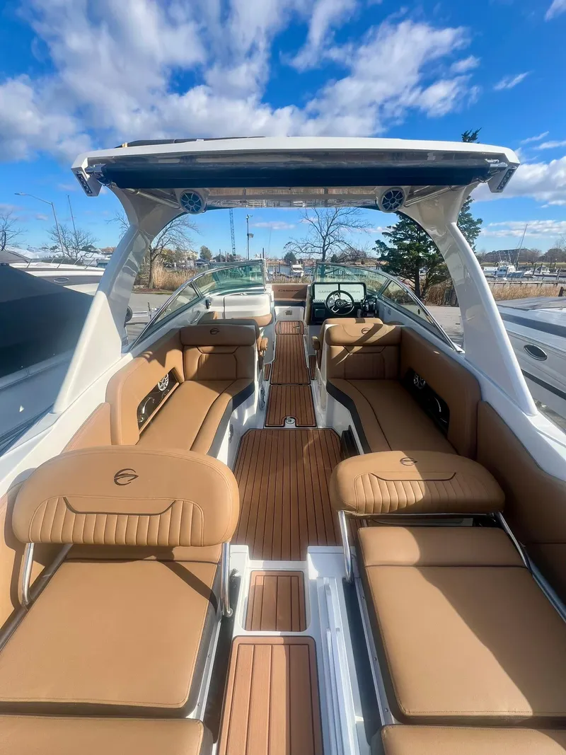 Slide: The Image of 2025 Crownline 310 XSS boat with luxurious tan seating and sleek design. - 4
