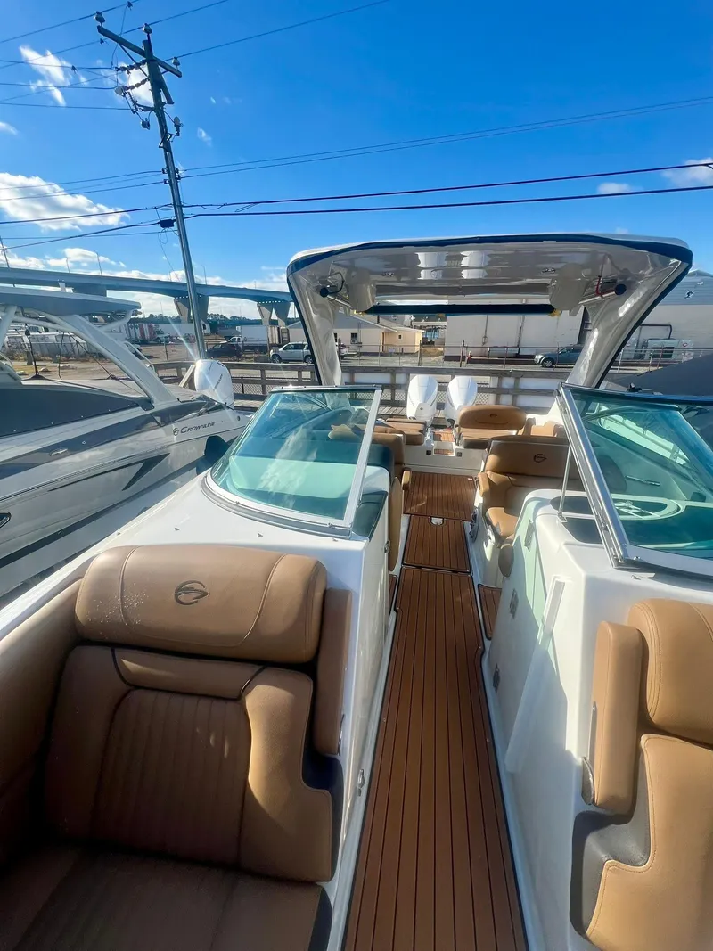 Slide: The Image of 2025 Crownline 310 XSS boat interior with tan seating and open deck. - 7