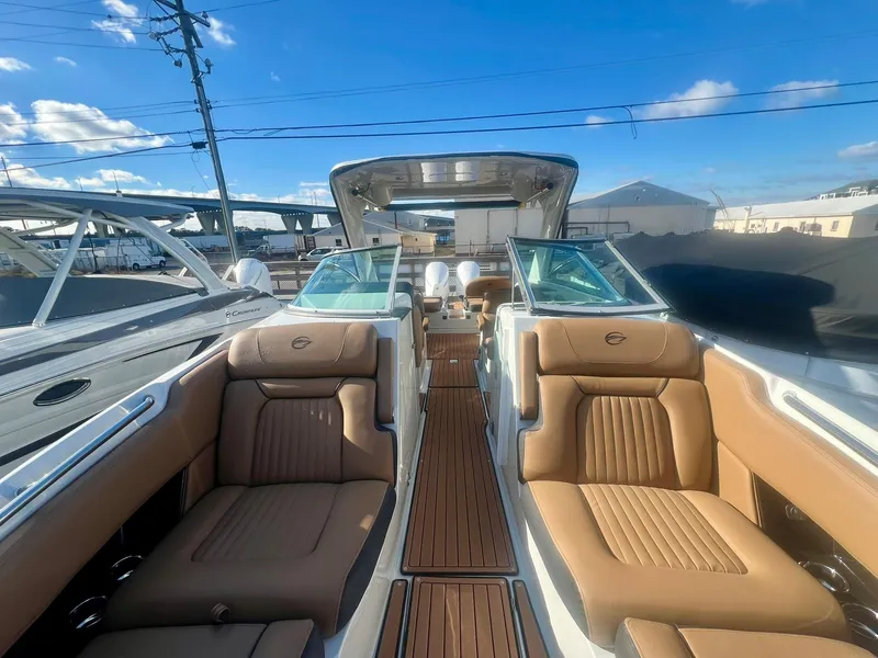 Slide: The Image of 2025 Crownline 310 XSS boat interior with tan leather seats and wooden flooring. - 9