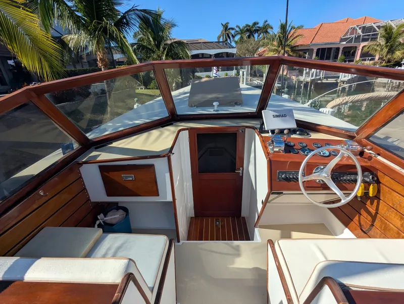 Slide: The Image of 1951 Huckins Fairform Flyer boat cockpit with wooden accents and steering wheel. - 10