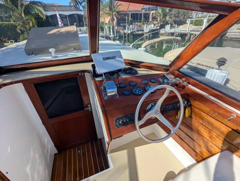 Slide: The Image of 1951 Huckins Fairform Flyer boat cockpit with wooden dashboard and steering wheel. - 11