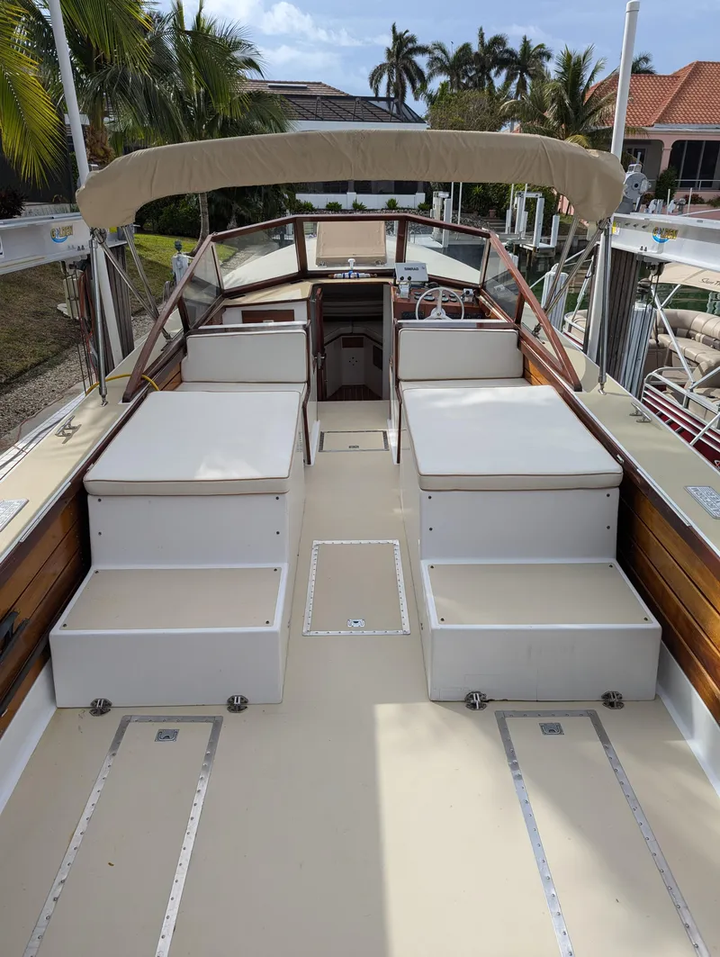 Slide: The Image of 1951 Huckins Fairform Flyer boat deck with seating, docked near palm trees. - 19