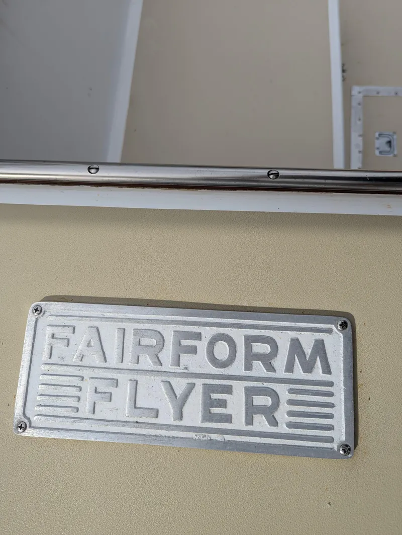 Slide: The Image of 1951 Huckins Fairform Flyer nameplate on beige surface. - 2