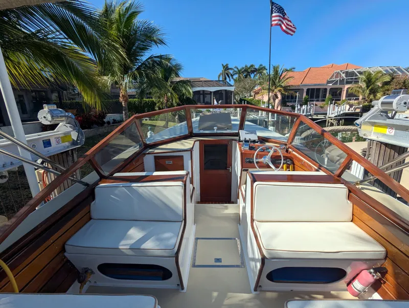 Slide: The Image of 1951 Huckins Fairform Flyer boat interior with seating, palm trees, and American flag. - 22