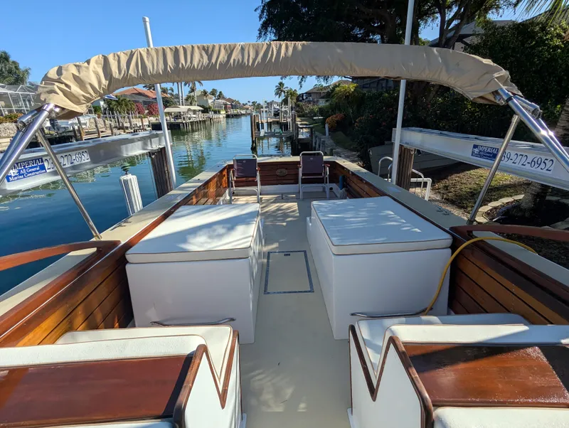 Slide: The Image of 1951 Huckins Fairform Flyer boat with wooden interior and canopy, docked by a canal. - 23