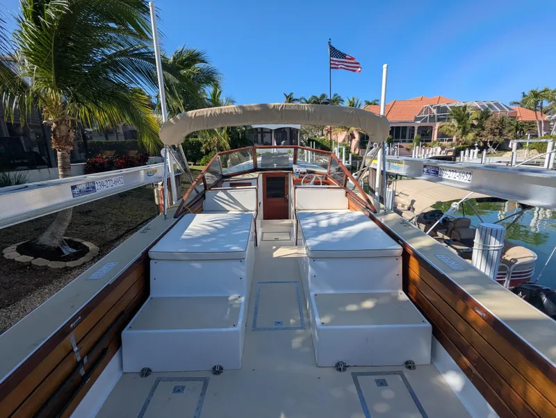 Slide: The Image of 1951 Huckins Fairform Flyer boat docked, featuring wooden deck and American flag. - 24