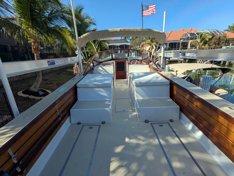 Slide: The Image of 1951 Huckins Fairform Flyer boat deck with American flag, palm trees, and waterfront view. - 25