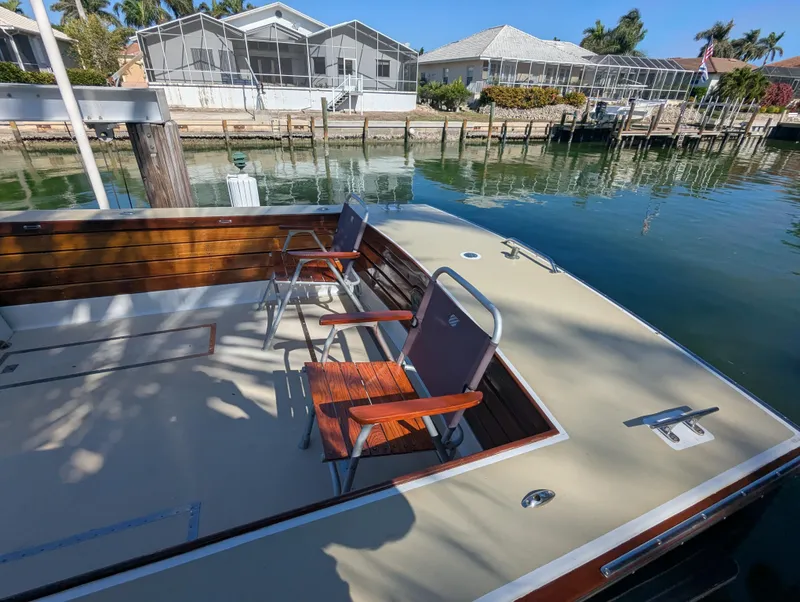 Slide: The Image of 1951 Huckins Fairform Flyer boat deck with chairs, docked by waterfront homes. - 26