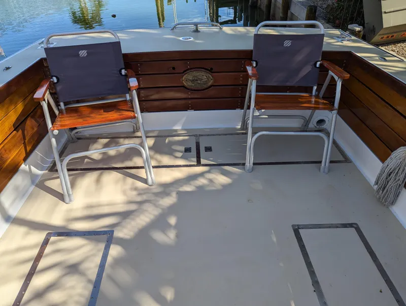 Slide: The Image of 1951 Huckins Fairform Flyer boat deck with two chairs and wooden paneling. - 27