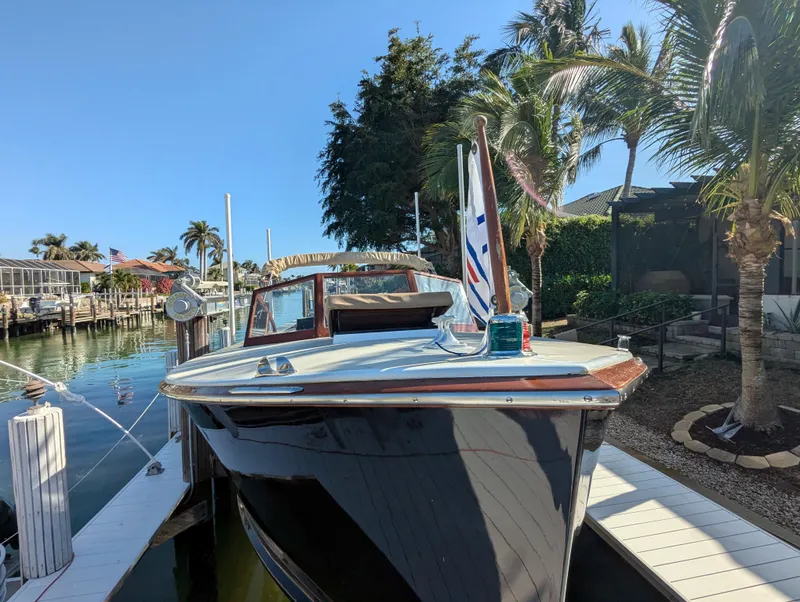 Slide: The Image of 1951 Huckins Fairform Flyer docked by palm trees in a sunny marina. - 3