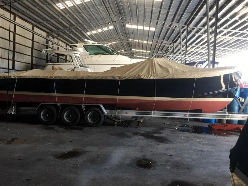 Slide: The Image of 1951 Huckins Fairform Flyer boat covered in storage on a trailer. - 36