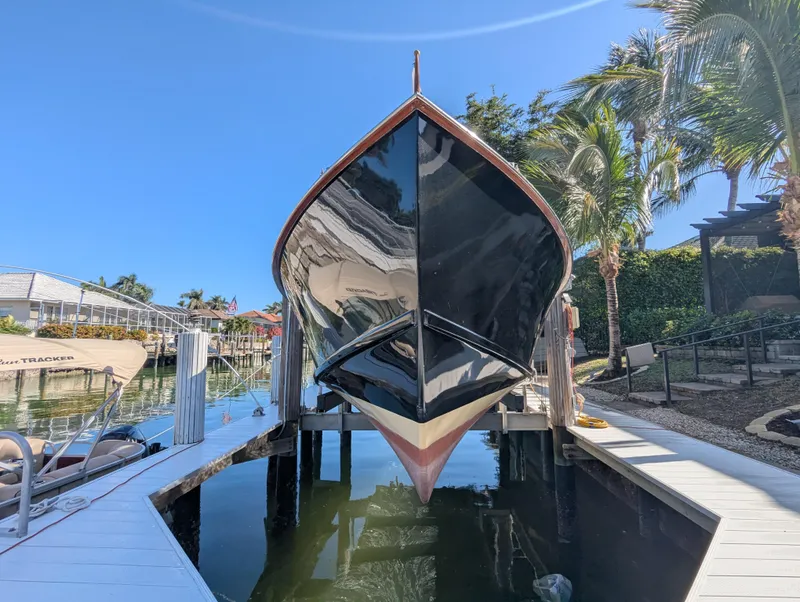 Slide: The Image of 1951 Huckins Fairform Flyer boat docked, front view, surrounded by palm trees and clear blue sky. - 4