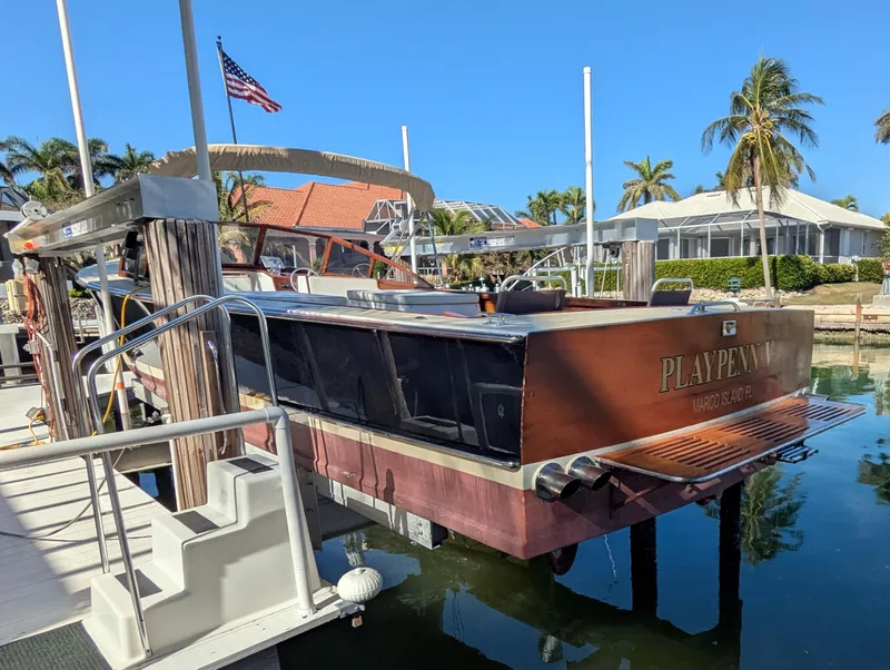 Slide: The Image of 1951 Huckins Fairform Flyer docked near palm trees and American flag. - 7