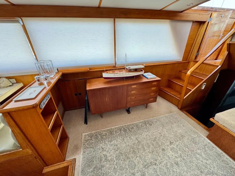 Slide: The Image of Interior of 1972 Stephens Brothers Flush Deck Motoryacht with wooden furnishings and model ship display. - 13