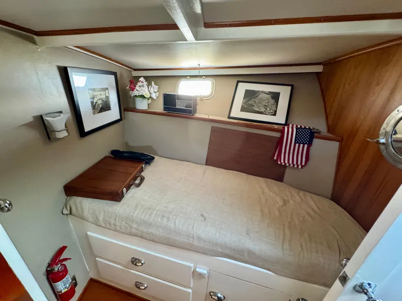 Slide: The Image of 1972 Stephens Brothers Flush Deck Motoryacht cabin with bed, framed art, and American flag decor. - 29