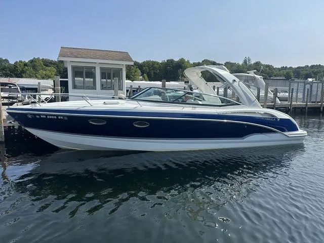 Slide: The Image of 2008 Formula 310 Sun Sport boat docked on calm water, featuring sleek design and blue hull. - 1