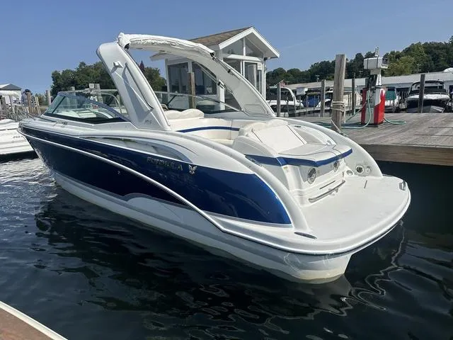 Slide: The Image of 2008 Formula 310 Sun Sport boat docked at marina, blue and white design. - 4