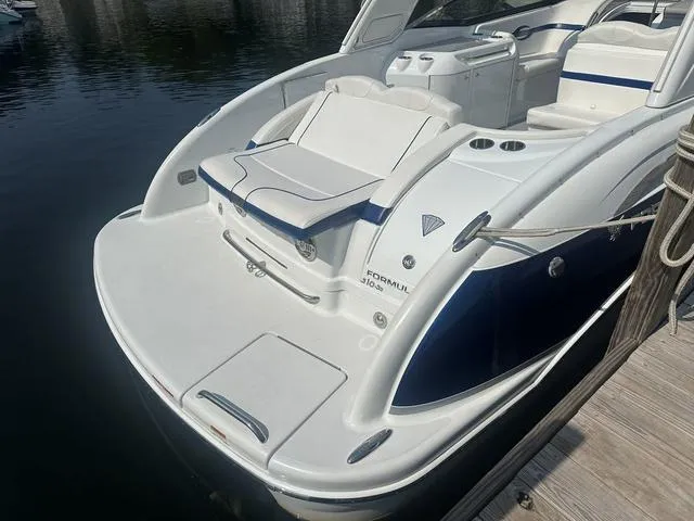 Slide: The Image of 2008 Formula 310 Sun Sport boat docked, featuring sleek white and blue design. - 8