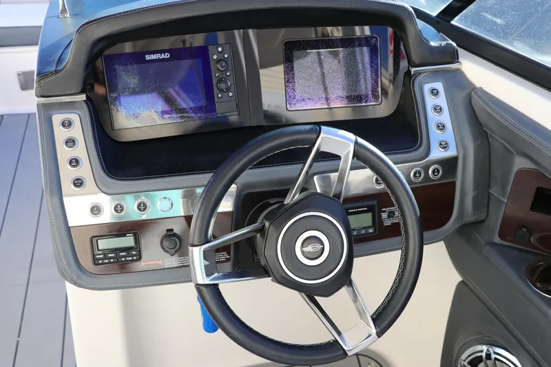 Slide: The Image of 2021 Chaparral 30 Surf boat dashboard with steering wheel and navigation screens. - 26